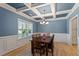 Elegant dining room featuring a coffered ceiling, hardwood floors, and ample natural light from a large window at 105 Blue Prince Trl, Holly Springs, NC 27540