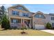 Charming two-story home with stone accents, covered porch, and colorful landscaping at 105 Blue Prince Trl, Holly Springs, NC 27540