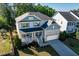 Attractive two-story home with stone accents, a welcoming front porch, and lush landscaping at 105 Blue Prince Trl, Holly Springs, NC 27540