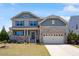 Charming two-story home with a combination of stone and shingle siding, complemented by a well-manicured lawn at 105 Blue Prince Trl, Holly Springs, NC 27540