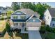 Charming two-story home boasts a stone facade, blue accents, and a manicured front yard at 105 Blue Prince Trl, Holly Springs, NC 27540