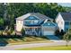 Beautiful two-story home featuring stone accents, a front porch, and well-maintained landscaping at 105 Blue Prince Trl, Holly Springs, NC 27540