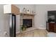 Close-up of a stone fireplace in the living room featuring a mantel, hearth, and adjacent decor at 105 Blue Prince Trl, Holly Springs, NC 27540