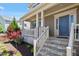 Inviting covered front porch with stone accents, a well maintained yard, and a charming entranceway at 105 Blue Prince Trl, Holly Springs, NC 27540