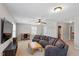 Spacious living room features a ceiling fan, ample natural light, and comfortable seating at 105 Blue Prince Trl, Holly Springs, NC 27540