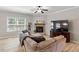 Comfortable living room featuring a stone fireplace, ceiling fan, and large window offering natural light at 105 Blue Prince Trl, Holly Springs, NC 27540