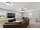 Living room boasts plenty of natural light, a ceiling fan, and a comfortable sectional sofa at 105 Blue Prince Trl, Holly Springs, NC 27540
