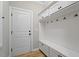 Well-organized mudroom with storage, a bench, hooks, and overhead cabinets for efficient storage solutions at 105 Blue Prince Trl, Holly Springs, NC 27540