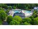 Overhead community view showcasing a pool, clubhouse, tennis courts, and playground surrounded by lush trees at 10523 Bedfordtown Dr, Raleigh, NC 27614
