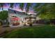 Outdoor living space includes a patio, hot tub, pergola, and spacious lawn at dusk at 10523 Bedfordtown Dr, Raleigh, NC 27614