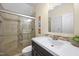 A modern bathroom features a glass enclosed shower with tiled walls, dark vanity and large sink at 10523 Bedfordtown Dr, Raleigh, NC 27614