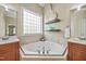 Well-lit bathroom featuring dual vanities, soaking tub, and natural lighting at 10523 Bedfordtown Dr, Raleigh, NC 27614