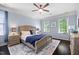 Charming bedroom with a ceiling fan, a soft rug, and two windows at 10523 Bedfordtown Dr, Raleigh, NC 27614