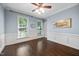 Empty bedroom with hardwood floors, a ceiling fan, and natural light from three windows at 10523 Bedfordtown Dr, Raleigh, NC 27614