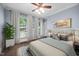 Neutral bedroom with a ceiling fan, three windows, and hardwood floors at 10523 Bedfordtown Dr, Raleigh, NC 27614