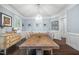 Elegant dining room with a rustic wooden table, chandelier, large window and stylish decor creating a warm ambiance at 10523 Bedfordtown Dr, Raleigh, NC 27614