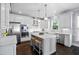 Bright kitchen features white cabinetry, stainless appliances, and a marble-topped island with seating at 10523 Bedfordtown Dr, Raleigh, NC 27614