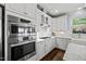 Kitchen with stainless double oven and cooktop, white cabinets, and stone counters at 10523 Bedfordtown Dr, Raleigh, NC 27614
