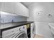 A well-equipped laundry room features side by side washer and dryer units and sleek countertop space at 10523 Bedfordtown Dr, Raleigh, NC 27614