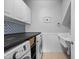 Well-equipped laundry room with countertop, ample storage, mosaic tile backsplash, and modern washer and dryer at 10523 Bedfordtown Dr, Raleigh, NC 27614