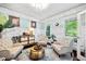 Charming living room featuring comfortable seating, unique decor, paneling, and natural light offering a relaxing space at 10523 Bedfordtown Dr, Raleigh, NC 27614