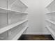 A walk-in pantry features white shelving on all sides with dark hardwood floors at 10523 Bedfordtown Dr, Raleigh, NC 27614