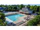 Attractive community pool and clubhouse with an abundance of lounge chairs and umbrellas on a sunny day at 10523 Bedfordtown Dr, Raleigh, NC 27614
