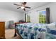 Bright bedroom with a ceiling fan, two windows, and a comfortable bed covered with a blue quilt at 11 Providence Ct, Durham, NC 27705