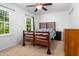 Bright bedroom with a wooden bed frame, ceiling fan, and large windows at 11 Providence Ct, Durham, NC 27705