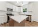 Bright kitchen features white cabinets, stainless steel appliances, an island with white countertops and wood flooring at 110 Cribbs Ln, Middlesex, NC 27557