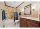 Cozy bathroom featuring a wooden vanity, marble countertop, and tiled shower with curtain at 11009 Eaglerock Dr, Raleigh, NC 27613