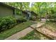 Home with a well-maintained lawn, mature trees, and charming garden gate entrance at 11009 Eaglerock Dr, Raleigh, NC 27613
