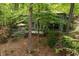Home exterior with a deck, lush landscaping and surrounding mature trees at 11009 Eaglerock Dr, Raleigh, NC 27613