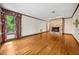 Empty living room with hardwood floors, stone fireplace, and natural light from the windows at 11009 Eaglerock Dr, Raleigh, NC 27613