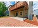 Townhome back patio with brick pavers, under deck, small yard, and lush green landscaping at 1101 Boxcar Way, Apex, NC 27502