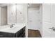 Hall bathroom with large mirror, dark vanity, white sink, and views of the doors across the hall at 1101 Boxcar Way, Apex, NC 27502