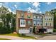 Exterior view of three-story townhomes with attached garages, blue sky, and mature landscaping at 1101 Boxcar Way, Apex, NC 27502