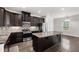 Well-equipped kitchen featuring granite countertops, stainless appliances, dark cabinets, and a spacious island at 1101 Boxcar Way, Apex, NC 27502