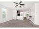 Open-concept living room features neutral carpet, ceiling fan, and view of the kitchen at 1101 Boxcar Way, Apex, NC 27502