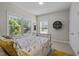 Bright bedroom with a metal frame bed and large windows offering natural light and views of the outdoors at 1103 Capstone Dr, Durham, NC 27713