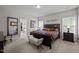 Bright bedroom with large bed, colorful quilt, bench seating, and lots of natural light at 1103 Capstone Dr, Durham, NC 27713