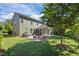 Exterior featuring a landscaped backyard with a patio, sunroom and well-manicured lawn, ideal for outdoor living at 1103 Capstone Dr, Durham, NC 27713
