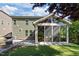 Exterior showcasing the sunroom, backyard, and patio of the residence in a tranquil green setting at 1103 Capstone Dr, Durham, NC 27713