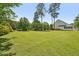 Spacious backyard featuring mature trees and a well-kept lawn at 1104 Dominion Hill Dr, Cary, NC 27519