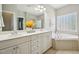 Bathroom with double vanity, a soaking tub, and a separate glass-enclosed shower provides a luxurious retreat at 1104 Dominion Hill Dr, Cary, NC 27519