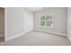 Bedroom features neutral carpet, double door closet, white trim, and a large window at 1104 Dominion Hill Dr, Cary, NC 27519