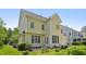 Back view of a yellow home with multiple windows, a brick patio, and lush landscaping at 1104 Dominion Hill Dr, Cary, NC 27519