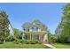 Inviting two-story home with a classic yellow exterior, covered front porch, and well-manicured landscaping at 1104 Dominion Hill Dr, Cary, NC 27519
