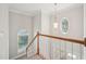 Staircase illuminated by decorative windows and a pendant light providing an elegant transition between levels at 1104 Dominion Hill Dr, Cary, NC 27519