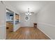 Bright dining room featuring wood floors, modern chandelier, and open view to the kitchen at 117 Candace Pl, Cary, NC 27513
